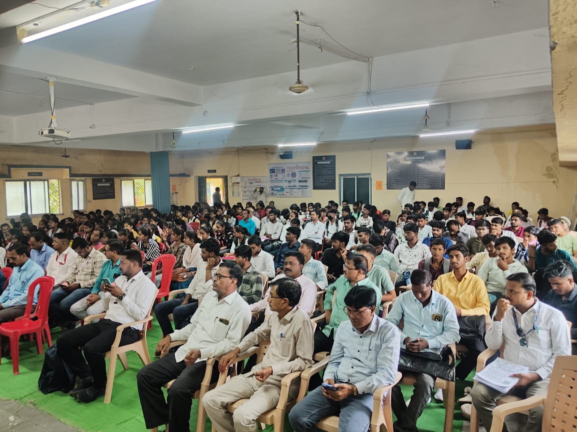 A light brown puppy standing on a white and tan woven pet bed.