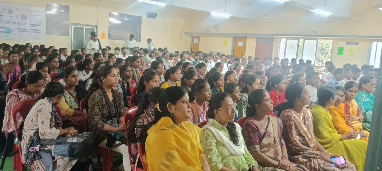 A light brown puppy standing on a white and tan woven pet bed.