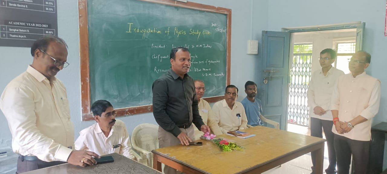 A light brown puppy standing on a white and tan woven pet bed.